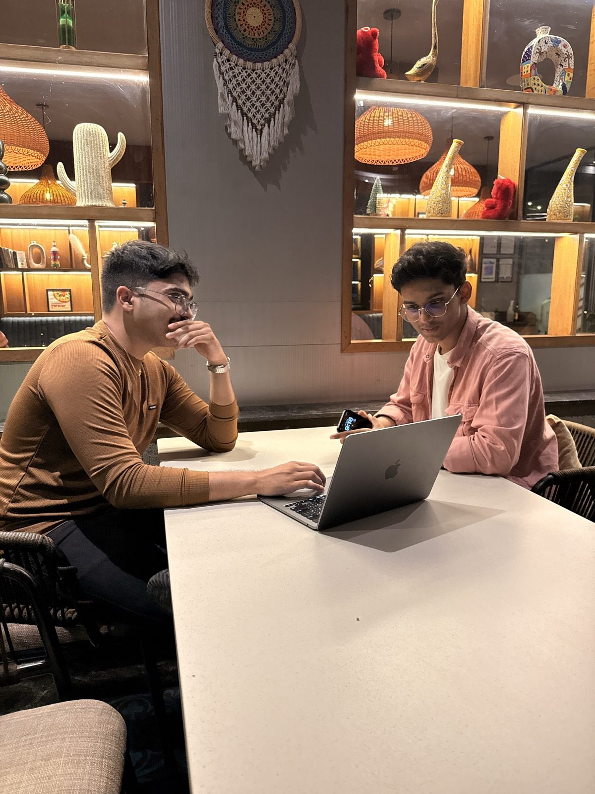 RapidXAI founder Shreyas Raj working through an AI build with a client at a cafe in Kothrud, Pune